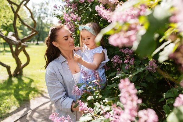 母性和人的概念 快乐的母亲带着小女儿在夏季公园或花园 — 图库照片