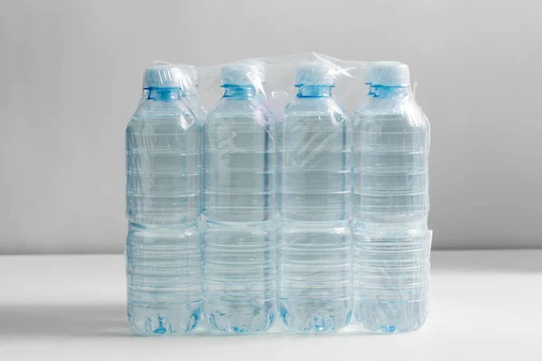 recycling, packing and storage concept - close up of plastic bottles with pure drinking water on table