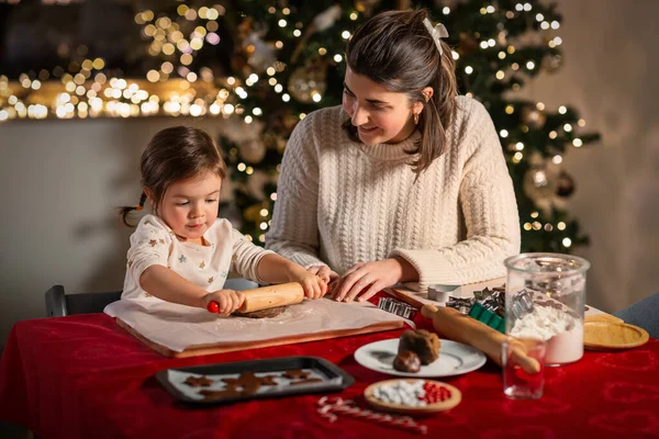 冬の休暇のコンセプト 幸せな母親と赤ちゃんの娘ローリングピンでジンジャーブレッドクッキーを作るクリスマスに自宅で生地から — ストック写真