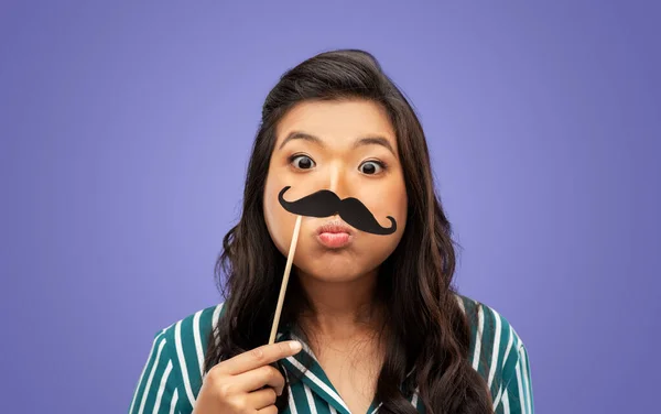party props, photo booth and people concept - woman with big black moustaches making face over violet background