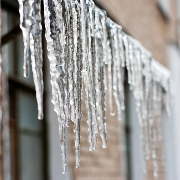 Icicli che pendono da un tetto — Foto Stock