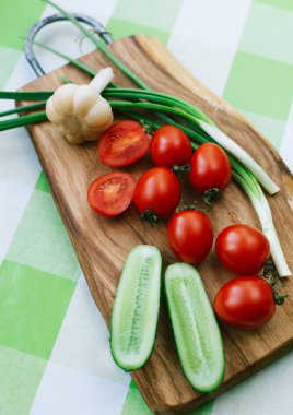 kesme tahtası üzerinde yeşil soğan ve domates