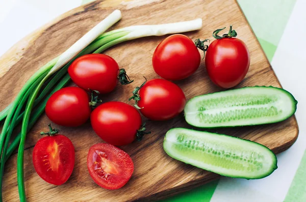 Pomidory czerwone i zielone cebule na deski do krojenia — Zdjęcie stockowe