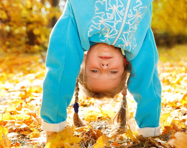 Girl on yellow leaves — Stock Photo, Image