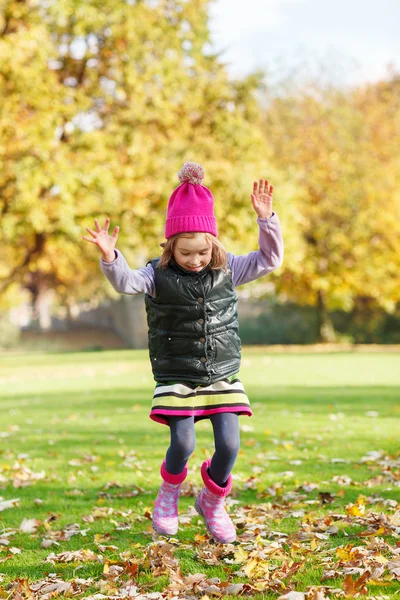 Chica saltando en el parque otoñal — Foto de Stock