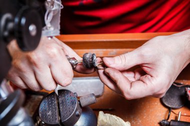 Kuyumcu altın küpe parlatır