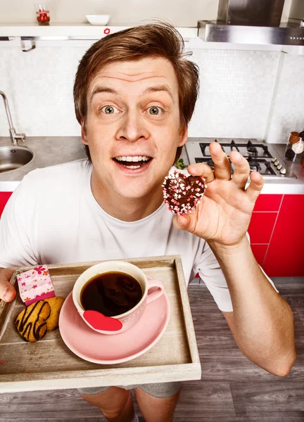 Homem alegre com café da manhã e biscoitos — Fotografia de Stock