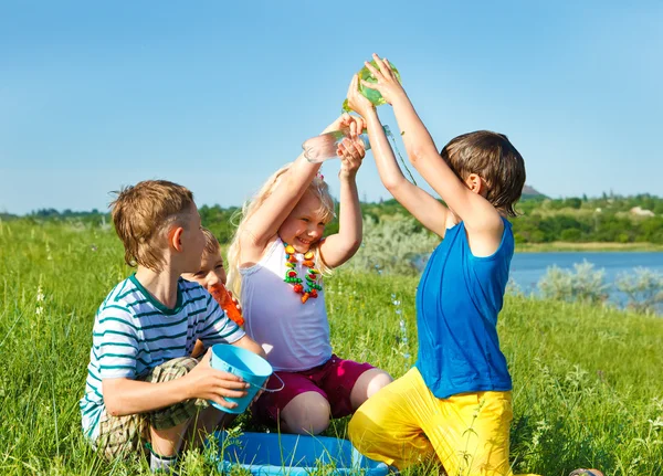 Excited friends pouring water — Stock Photo, Image