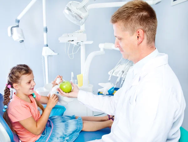 Dentista dando una manzana — Foto de Stock