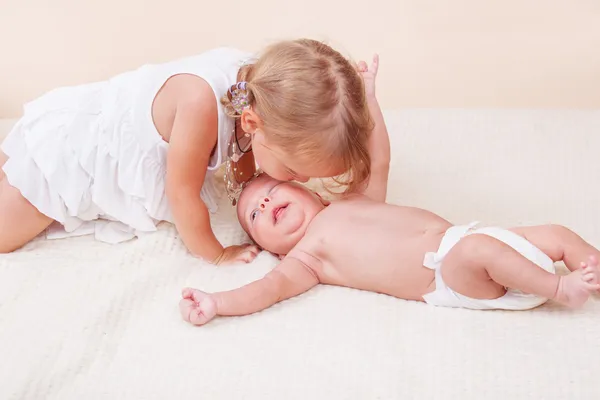 Sister kissing her baby brother — Stock Photo, Image