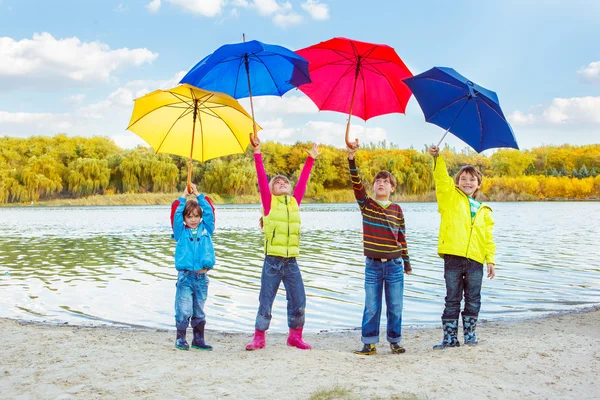 Jungen und Mädchen mit Regenschirmen — Stockfoto