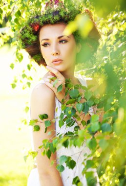 Young beauty among greenery