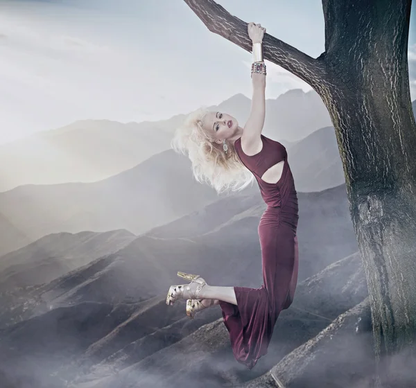 Привлекательная блондинка висит на дереве — стоковое фото