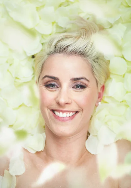 Aantrekkelijke korte-haar vrouw onder de witte bloemblaadjes — Stockfoto
