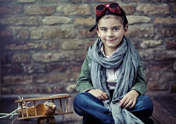 Mignon garçon souriant avec avion en bois — Photo