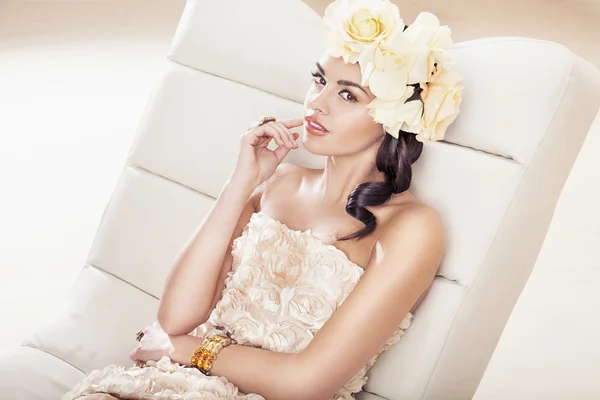Mooie brunette vrouw met fantastische bloem hoed — Stockfoto