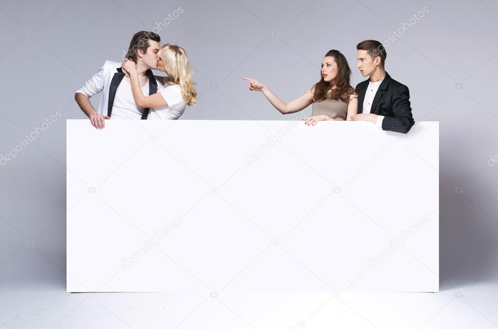 Surprised friends staring at kissing couple
