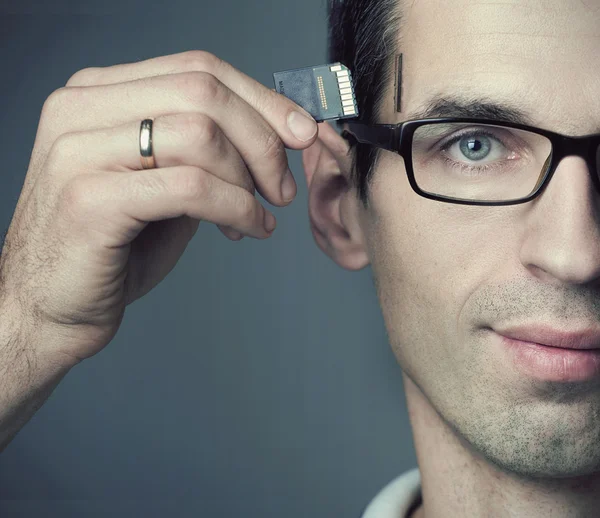 Young man inserting a SD Card into his head — Stock Photo, Image