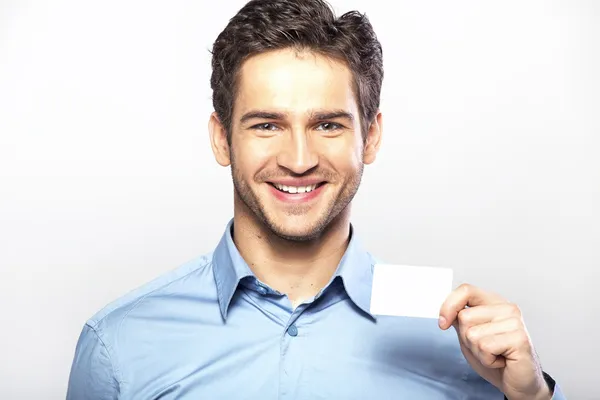 Lachende knappe jongen met visitekaartje — Stockfoto