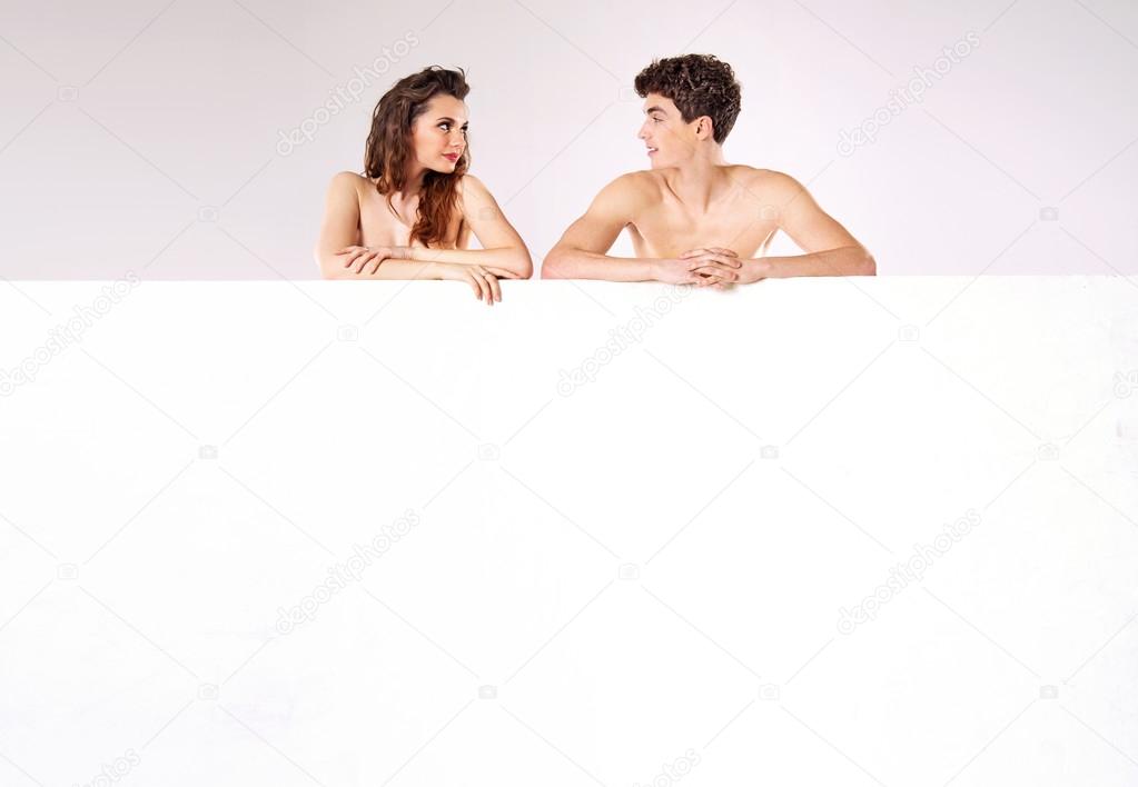 Attractive nude couple behind the board
