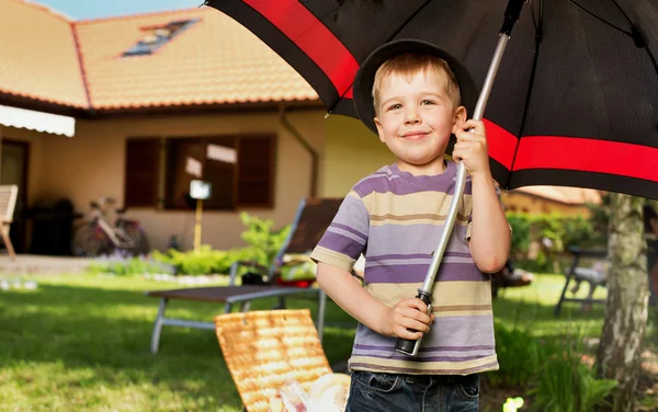 Imagem de um menino com um grande guarda-chuva — Fotografia de Stock