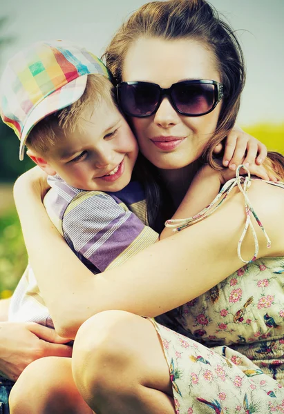 Όμορφη μαμά να αγκαλιάζει το γιο της χαριτωμένο美丽的妈妈抱着她可爱的儿子 — Φωτογραφία Αρχείου