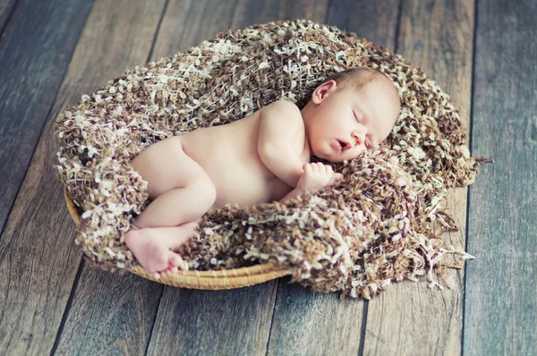 Pasgeboren baby slaapt in een rieten mand — Stockfoto