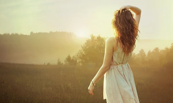 Гарненька брюнетка жінка дивиться захід сонця — стокове фото
