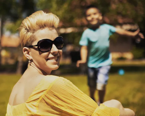 Retrato de la madre sonriente y su hijo en el fondo — Foto de Stock