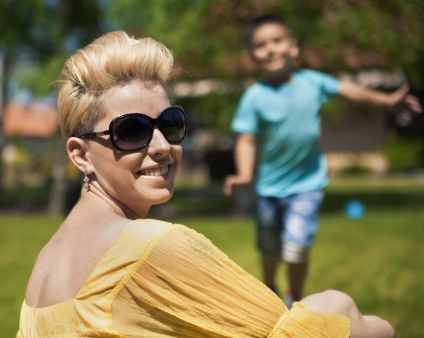 Mooie moeder en haar zoon in de achtergrond — Stockfoto