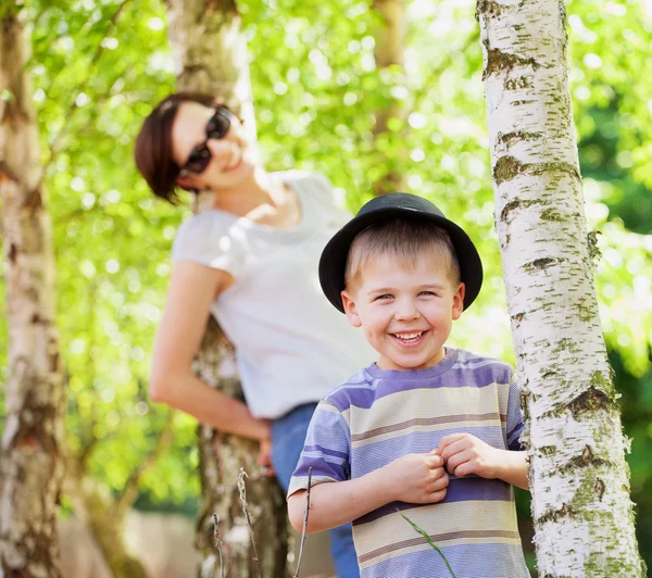 Glimlachend kind en zijn moeder in de achtergrond — Stockfoto