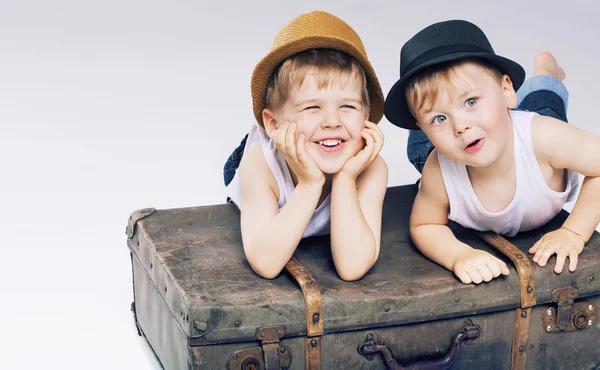 Dois irmãos bonitos deitado em luggages — Fotografia de Stock