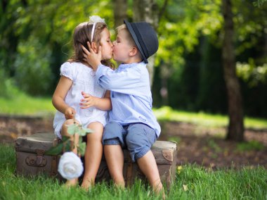 Cute couple of children kissing each other clipart