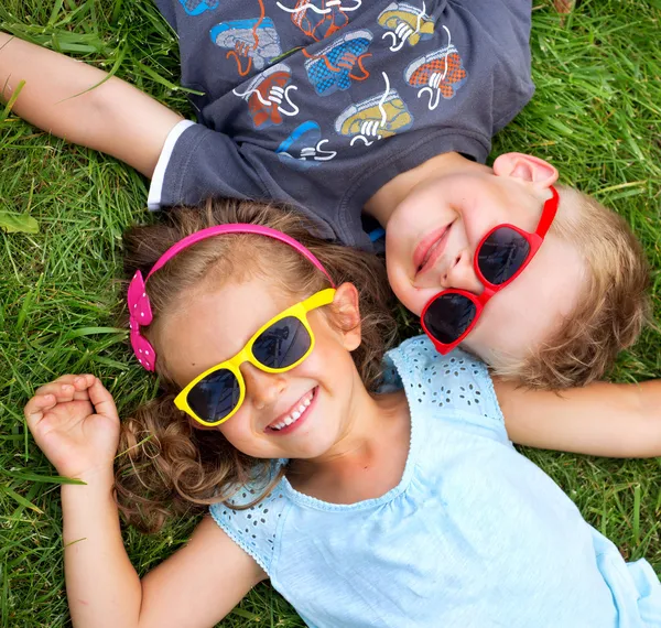 Imagen que presenta a los niños relajados en la hierba — Foto de Stock