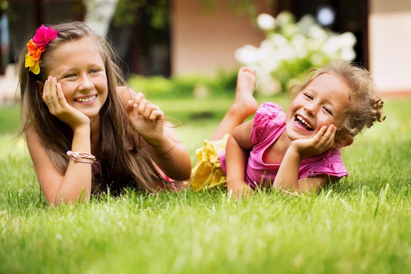 Mladé sestry spolu hrají v jejich zahradě — Stock fotografie