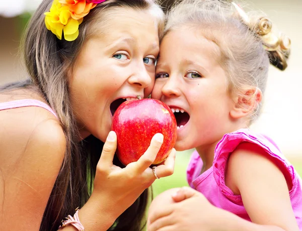 Vrolijke schattige kinderen delen een appel — Stockfoto