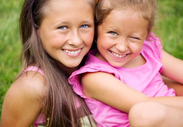 Mooie foto van twee schattige zusters rust in de tuin — Stockfoto