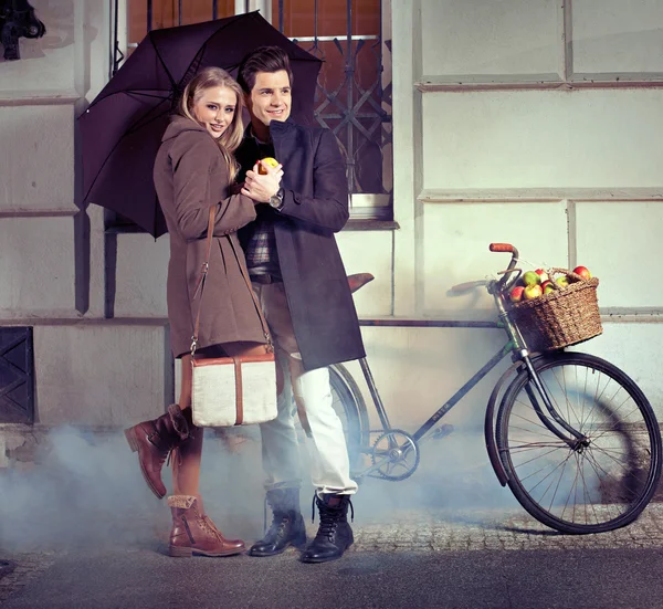 Елегантна пара з парасолькою в дощовий вечір — стокове фото