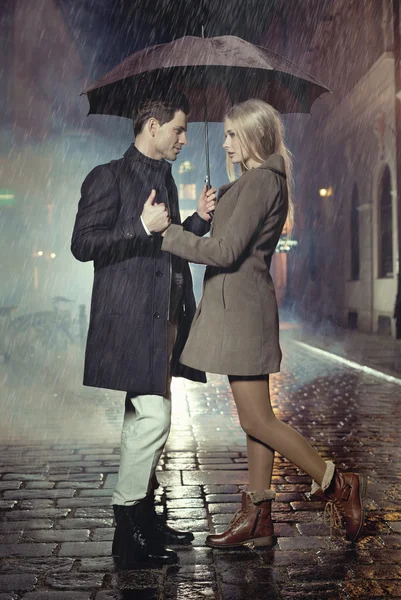 Young couple posing in heavy rain — Stock Photo, Image