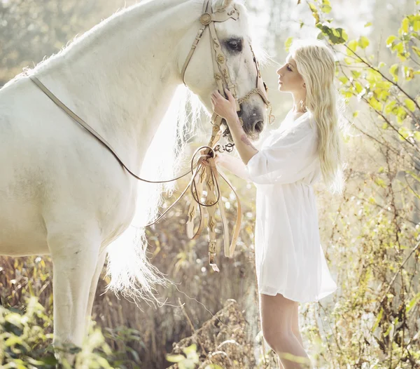 Blondynka piękna kobieta dotyka konia mejestic — Zdjęcie stockowe