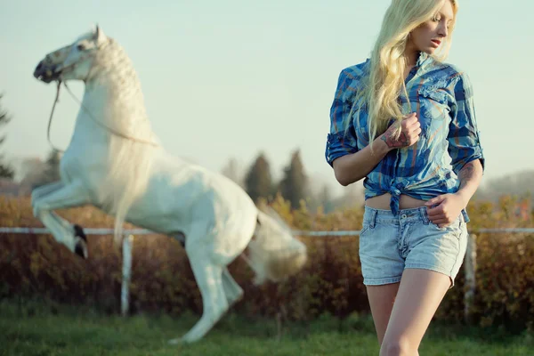 Verleidelijke blonde schoonheid met majestueuze paard — Stockfoto