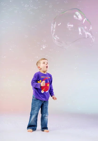 Ładny, mały chłopiec, ciesząc się baniek mydlanych — Zdjęcie stockowe