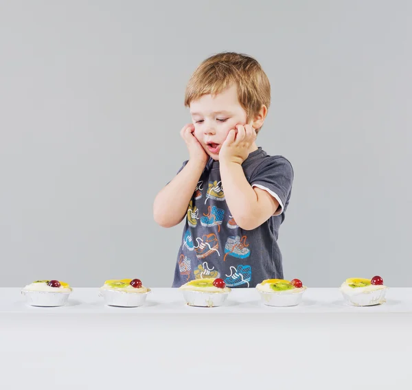 小さな男の子と多くのお菓子 — ストック写真