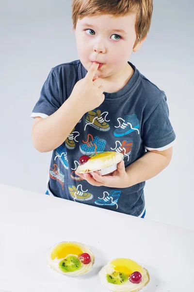 フルーツ ケーキの試飲小さな男の子 — ストック写真