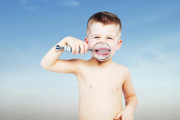 Prachtige kleine jongen op zoek door een vergrootglas — Stockfoto