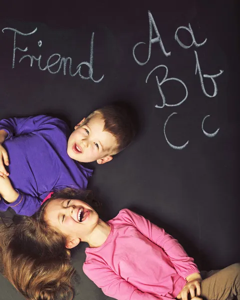 Cute kids playing on the black board — Stock Photo, Image