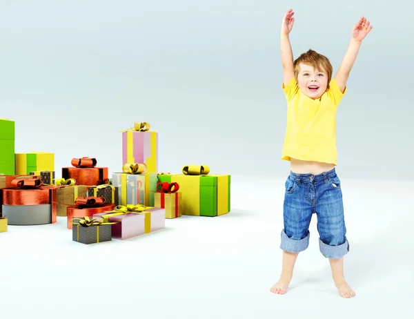 Cute little boy with lots of gifts — Stock Photo, Image