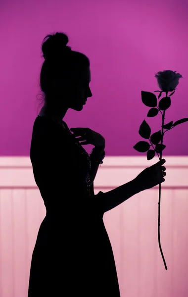 Silhueta feminina segurando a rosa — Fotografia de Stock