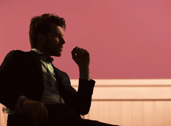 Красивый парень, сидящий на стуле Стоковое Изображение