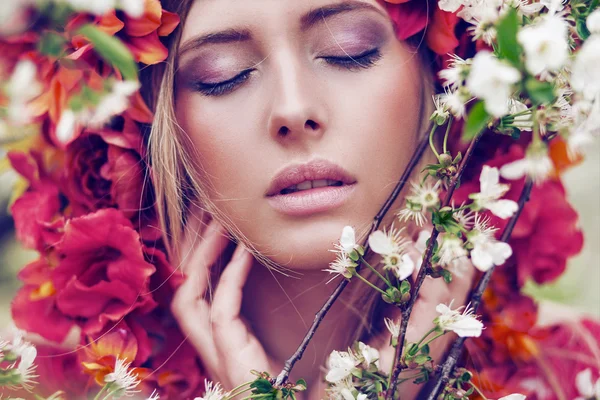 Sensuele blonde vrouw met bloemen — Stockfoto